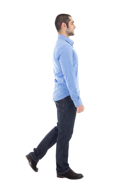 Side view of young arabic business man in blue shirt walking isolated on white background