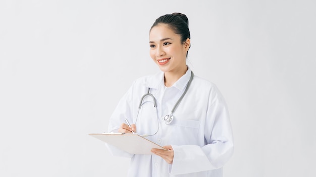 Side view of young asian female doctor writing on clipboard