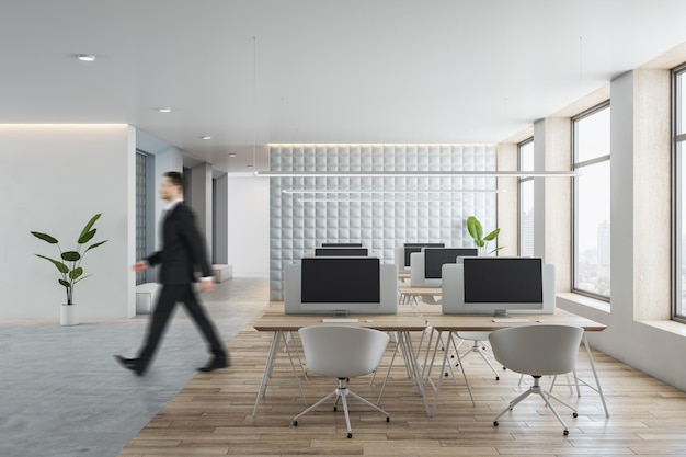 Side view of young businessman walking in modern concrete and wooden coworking office interior with furniture window and city view equipment CEO and executive concept