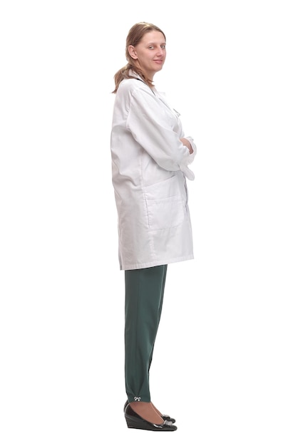 Side view of young female doctor or nurse standing over white background thoughtfully and looking forward.