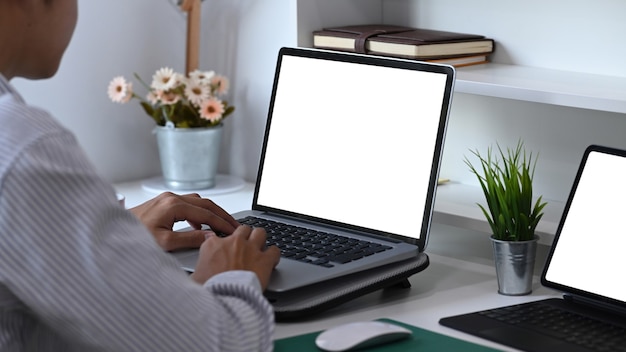 Side view of young male working with multiple electronic devices