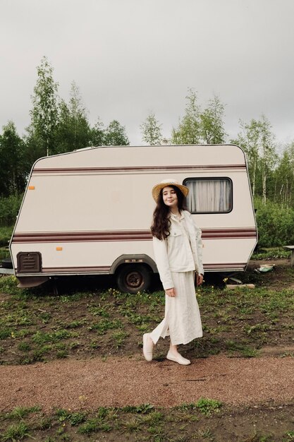 Photo side view of young woman standing by car against sky