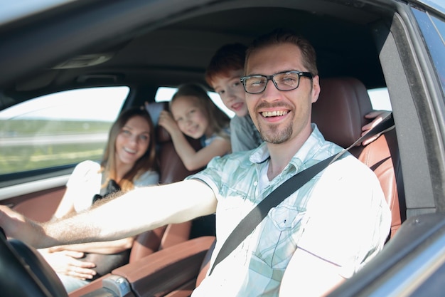 Side viewhappy father driving a car the concept of freedom and travel