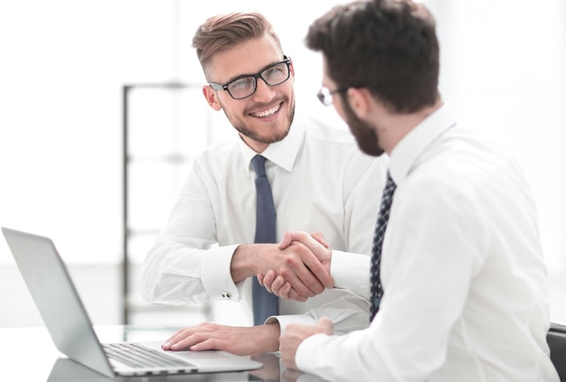 Side viewsmiling employees shaking hands