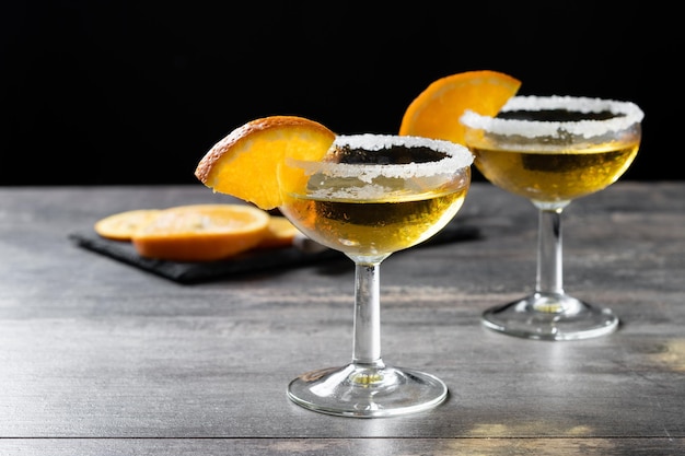 Sidecar cocktail with a sugar rim on wooden table