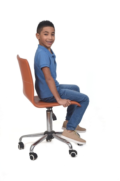 Sided view of a teen sitting on a chair on white background