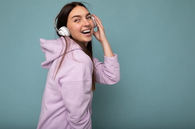 Sideprofile photo of beautiful happy smiling young brunette woman wearing light purple hoodie