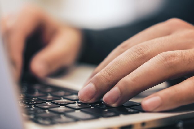 Photo sideview of male using laptop on table