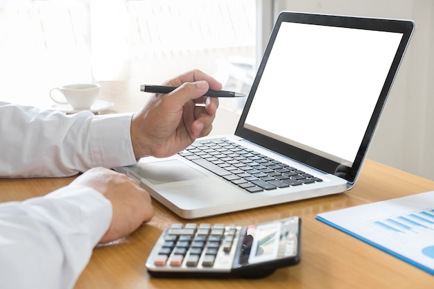 Sideview of office desktop with blank laptop and various office tools 