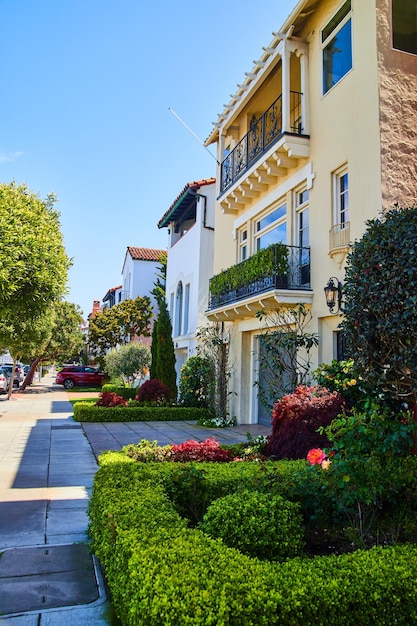 Sidewalk in front of beach houses with well trimmed hedges