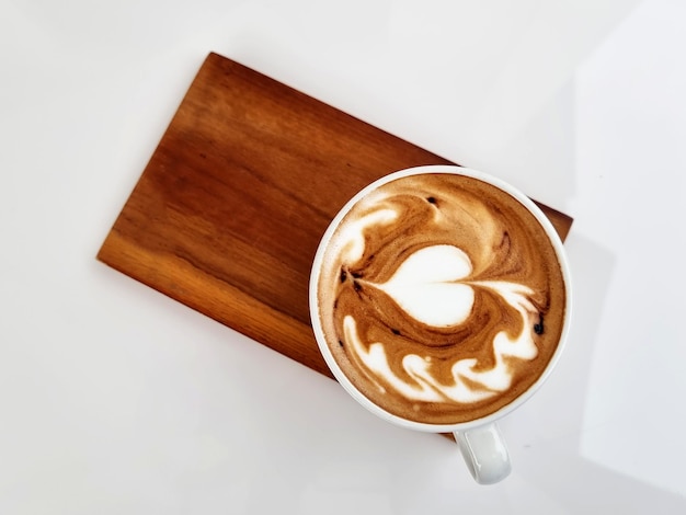 Sideway shop coffee Top view a cup of hot latte art coffee on wooden plate