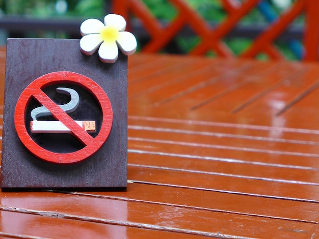 The sign is made of stucco on a red wooden table in a restaurant