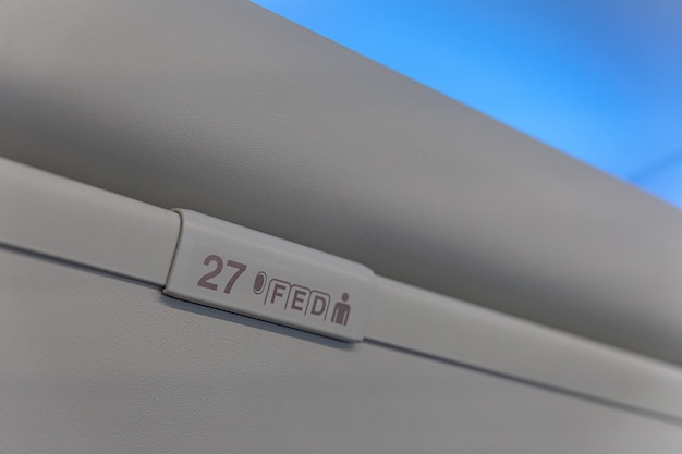 Sign of seat number with number and letter on luggage shell inside passenger airplane