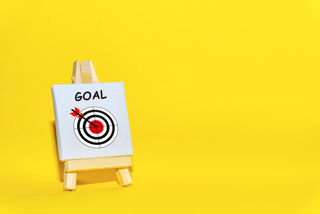 Sign stand with an arrow in the target  on a yellow background hit exactly on center. Concept of focusing on a target