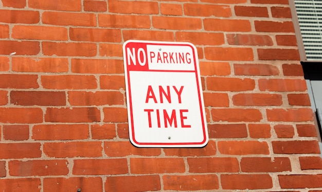 A sign that says no parking any time on it