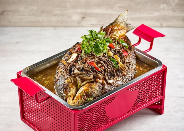 Signature fish with Mushroom Herbs in a dish isolated on stew on mat side view on grey background