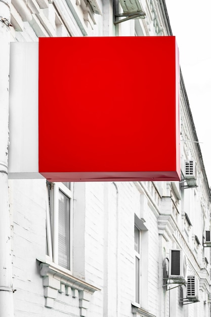 Photo signboard mockup square red sign of a store on the wall of a house