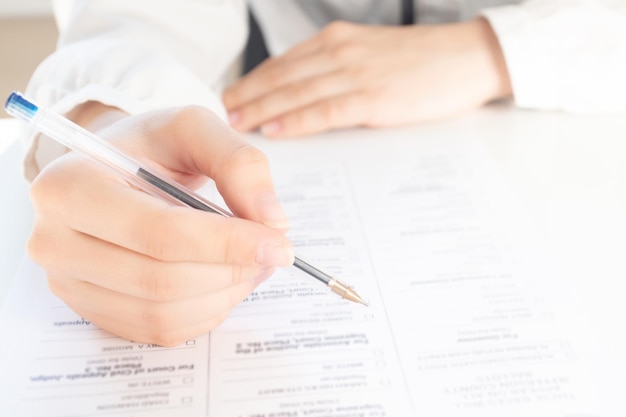 Signing documents for a pledge at home Hands hold a pen over paper