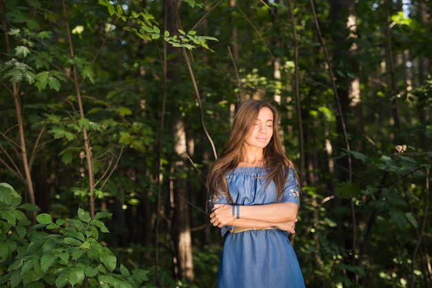 Silence, nature, people and summer concept - Young woman enjoying the green forest.