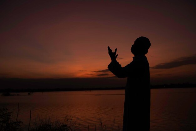 Silhouette of asiam muslim prayer on sunsetRamadan Festival Conceptbless allah