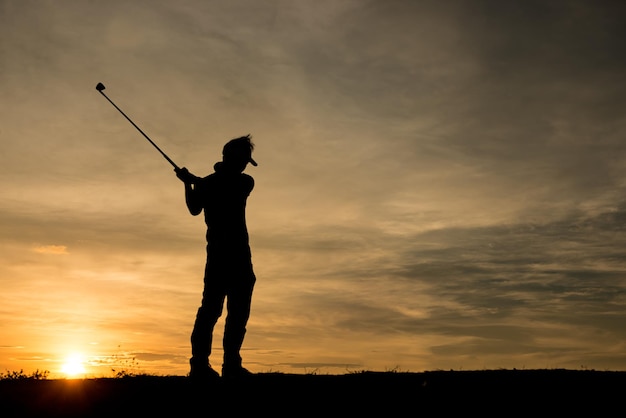 Silhouette asian golfer playing golf during beautiful sunset