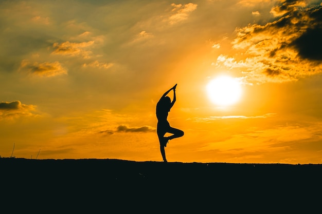 Silhouette of a beautiful Yoga woman in the sunset