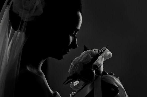 Silhouette of a bride's wedding bouquet sniffing