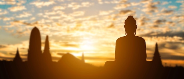 Silhouette of Buddha on golden temple sunset background Travel attraction in Thailand