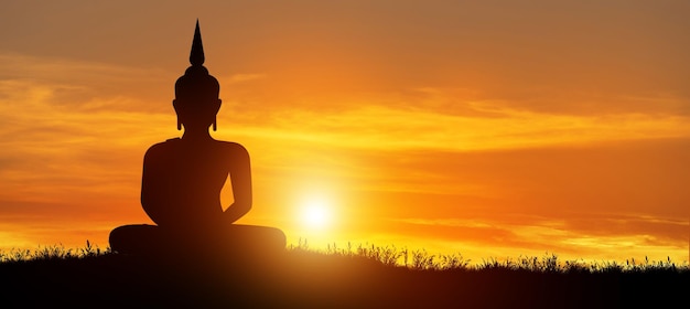 Silhouette of Buddha mediating in the twilight with sunrise background Buddhist holiday Concept