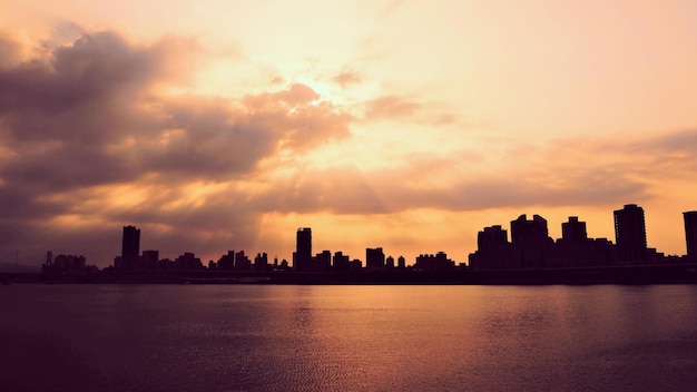 Photo silhouette buildings against sky during sunset