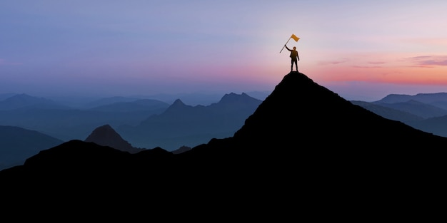 Silhouette of Businessman standing on mountain top over sunset twilight background with flag, Winner, Success and Leadership concept