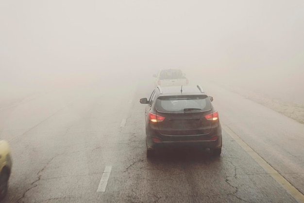 Silhouette of the car in heavy rain heavy fog on the road Poor visibility