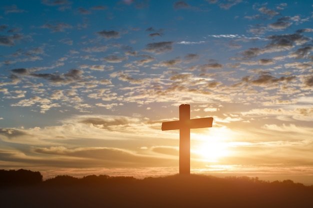 Silhouette of catholic cross, Crucifixion of Jesus christ at sunset background.