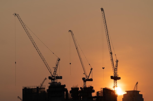 Silhouette construction view of cranes at sunset