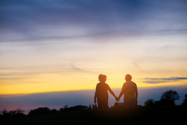 Silhouette of couple holding hands