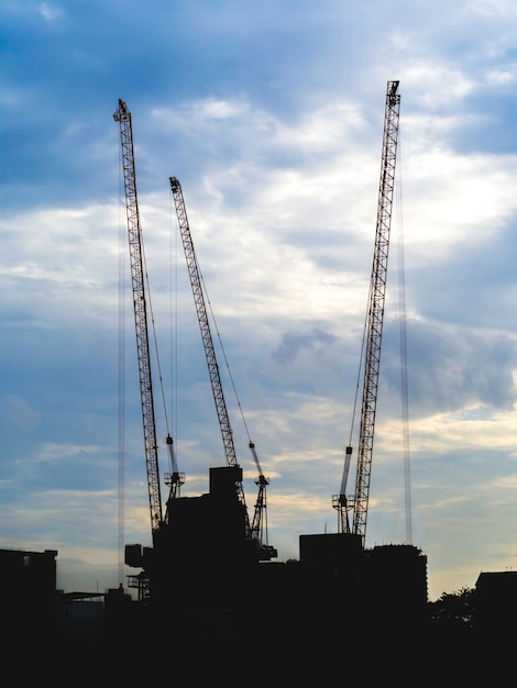 Silhouette crane at building construction site