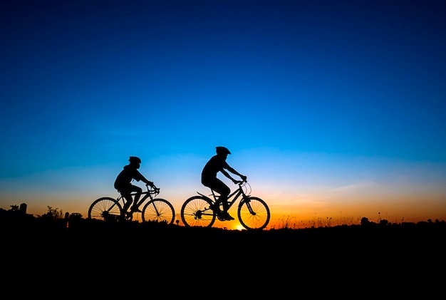 Silhouette of cycling on sunset background