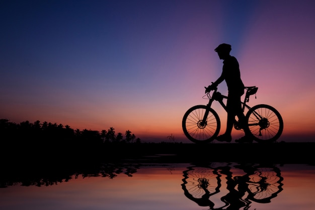 Silhouette of cyclist with mountain bike on beautiful sunset time.