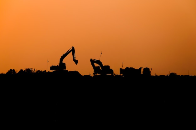 silhouette of excavator loader at construction site