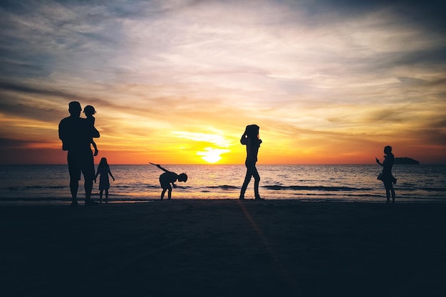 Photo silhouette family at beach