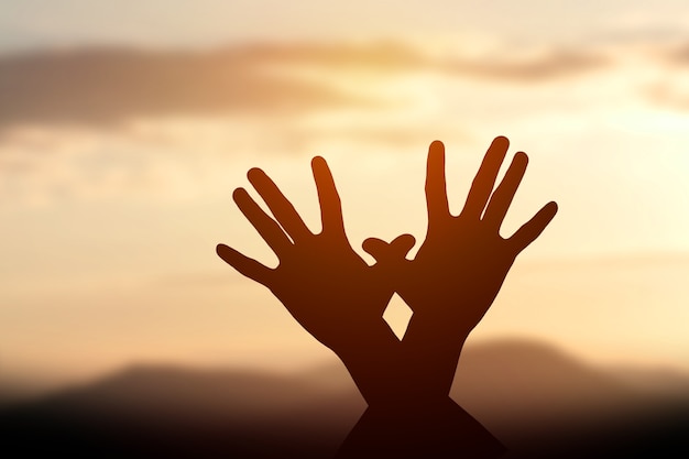 silhouette of female hands during sunset