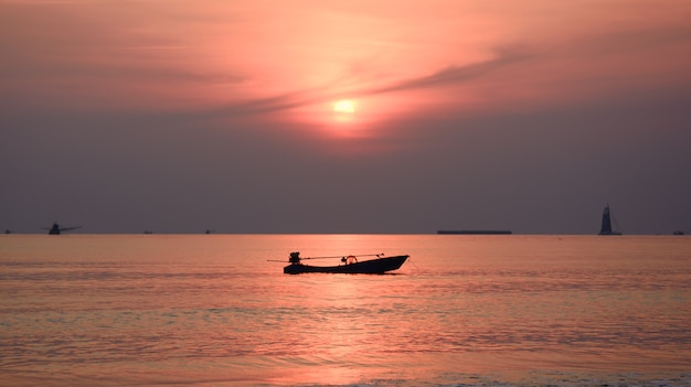 silhouette of fisherman boat with sunset background