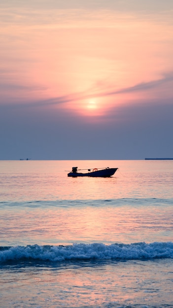 silhouette of fisherman boat with sunset background