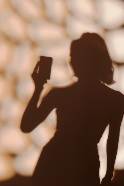 Silhouette of graceful woman taking a selfie