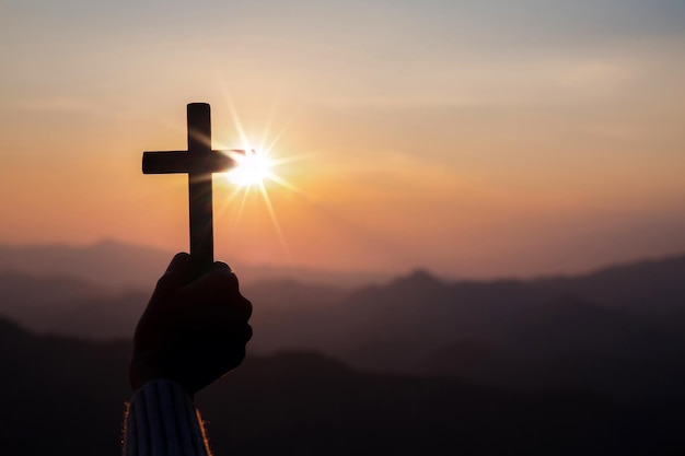 Silhouette hand holding cross