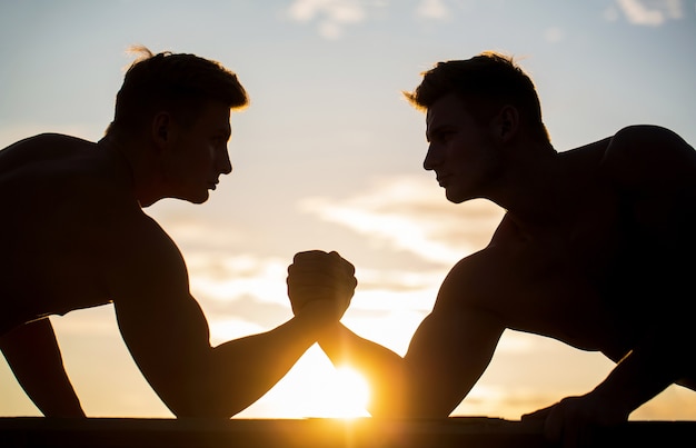 Silhouette of hands that compete in strength.