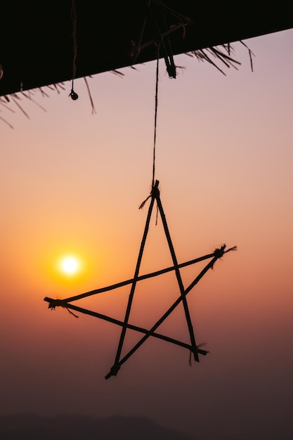 Silhouette hanging star on sunset background