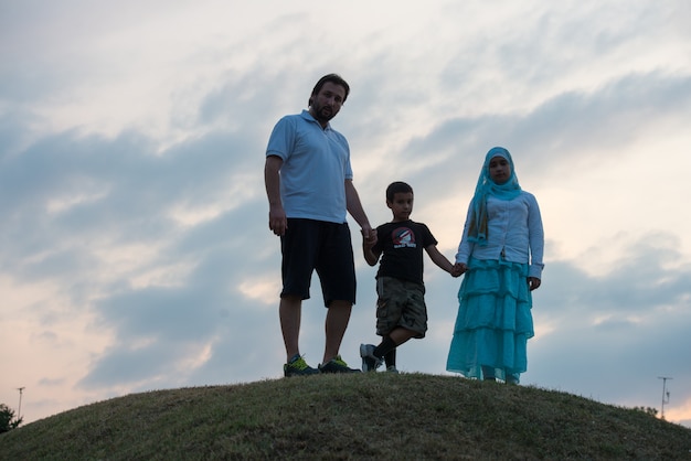 silhouette of happy family enjoying themselves on cliff