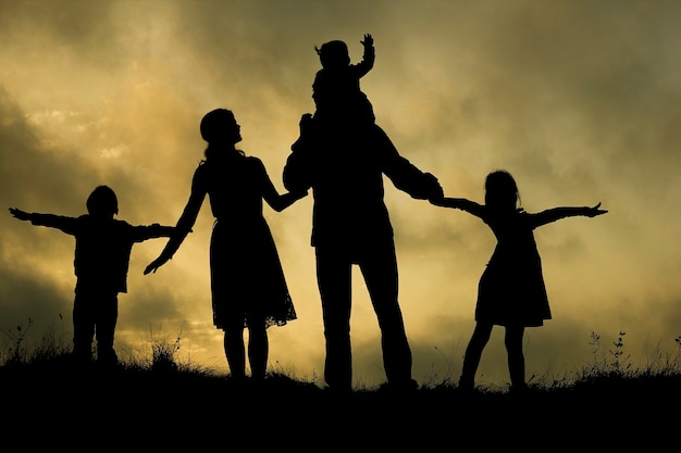 Silhouette of a happy family with children on nature
