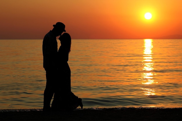 silhouette of a happy loving couple at sunset on the seashore